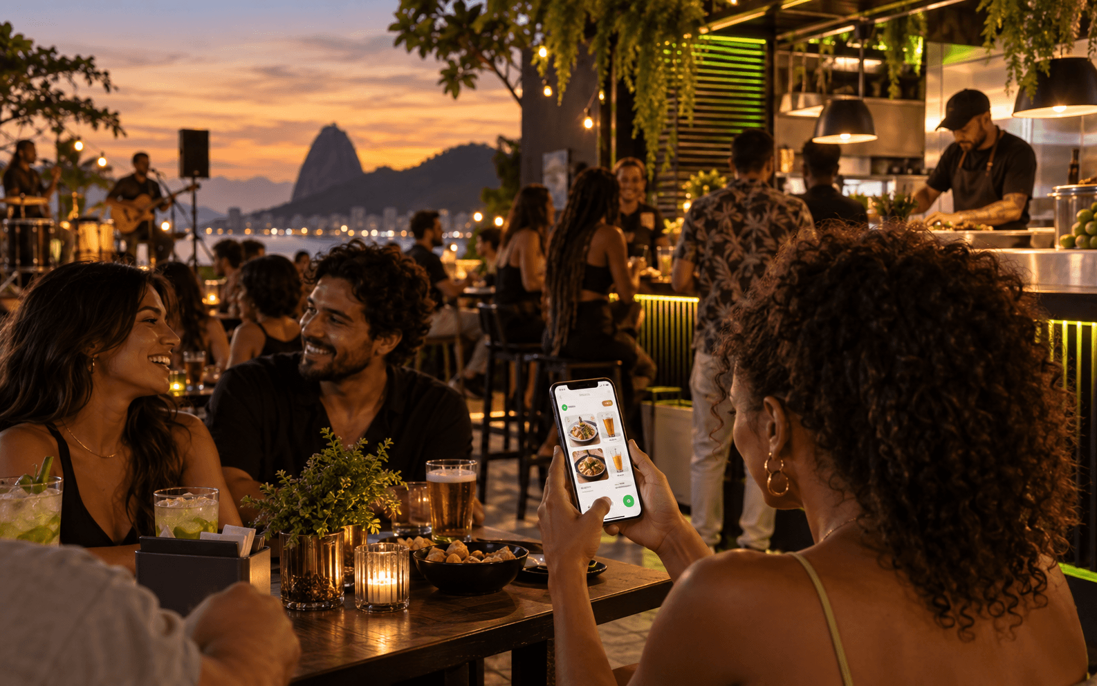 Pessoas em um espaço de música e alimentação, com pedido no celular
